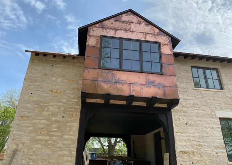Copper metal panel facade on a stone building for Roof Repair in Sioux City